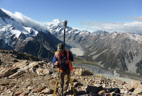 Man setting up research camera at the top of a mountain