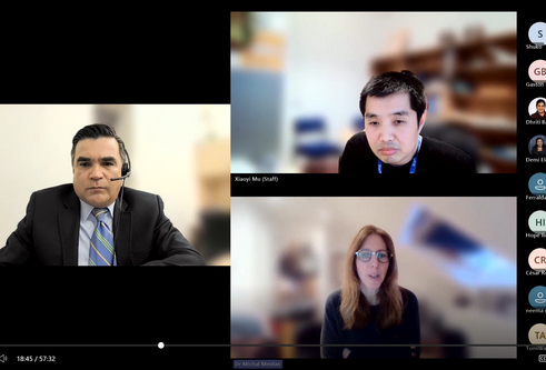 A screenshot of a webinar, three people are tiled together over the screen and a list of smaller tiles with initials sits down the right side of the screen.