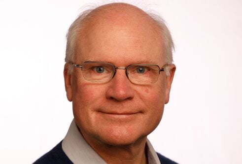 Prof Sir Mike Ferguson looking straight at the camera against a white background