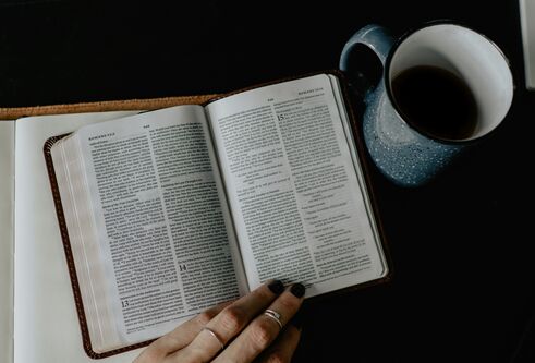 An overhead image of a book and cup of coffee