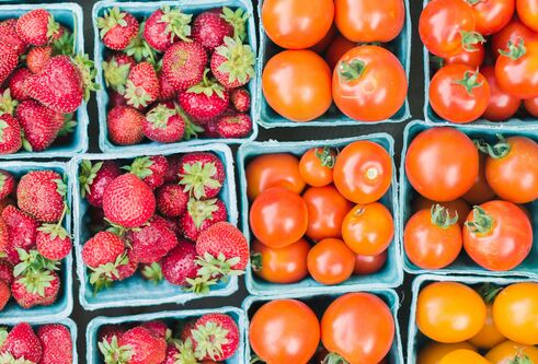 An overhead view of punnets of strawberries and tomatoes