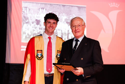 Sports Union presidents Rory La Trobe (2025-26 season) and John Carvell (1967-68 season) stand together at an event. Rory wears the Sports Union President gowns, John wears a suit and holds a framed certificate