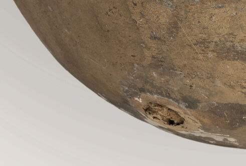 A section of a rounded bronze/stone sculpture.