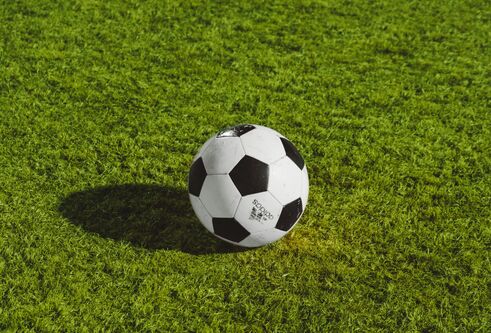 A traditional black and white-panlelled football on bright green grass