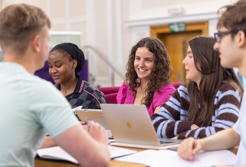 students smiling around a desk