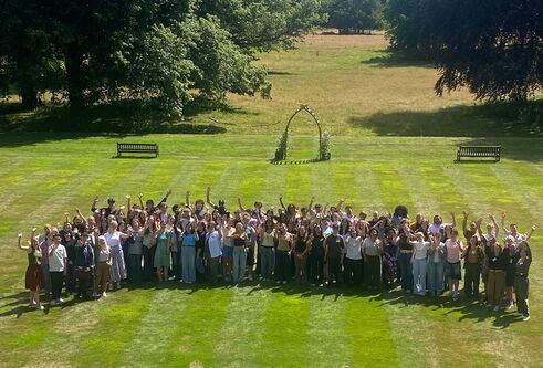 A large group of people stood together on a lawn