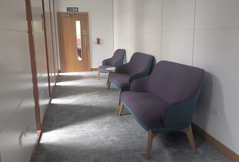 A row of sofa's and a chair in a hallway