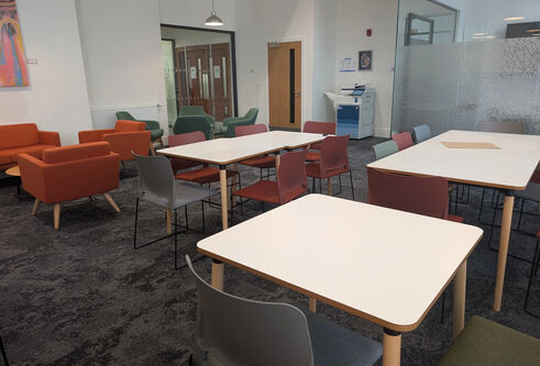 A study area in OMS with single chairs, tables with several chairs and arm chairs