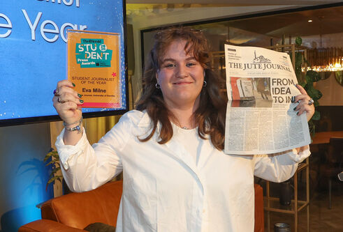 Eva Milne holding a student award and the newspaper The Jute Journal