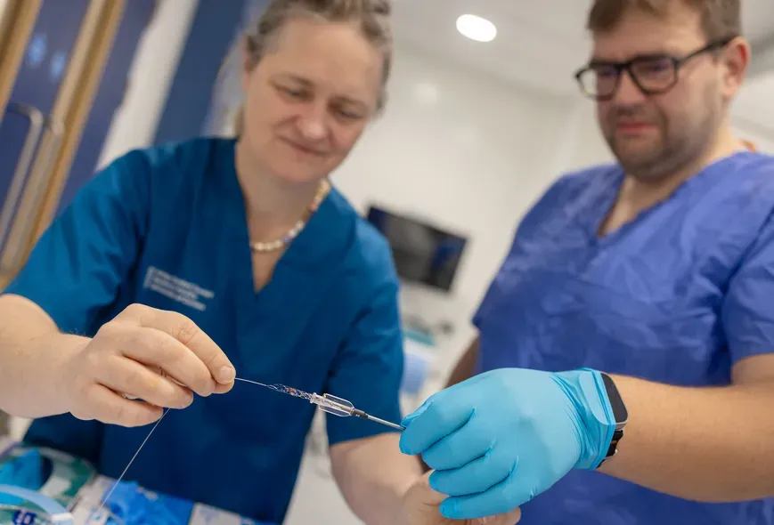 close up shot of two medical workers holding a piece of medical equipment 