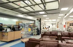 2 brown leather sofas, people sitting and some food on display to buy