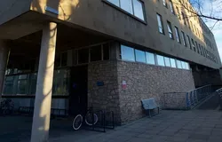 a building entrance with a ramp. There is also a bike and a bench
