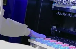 A person in PPE moving samples into or out of a fridge