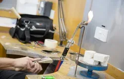 Hands working with a flame and blocks of material