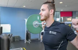 A gymgoer lifting weights at the Strength Performance Centre