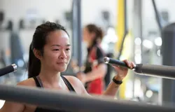 Girl using one of the machines in the gym.