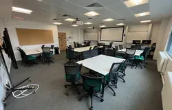Dalhousie 1G06  - several white tables set in squares with black chairs spread out across the room