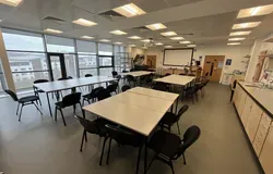 Dalhousie 1S03  - several tables set in squares with chairs and a white screen on the wall