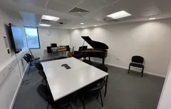 Dalhousie 1S11 - music room with a piano and tables set in a square with chairs