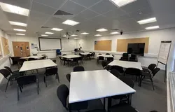 Dalhousie 2F14 - several tables set in squares with chairs and a tv mobile screen and white screen on the wall