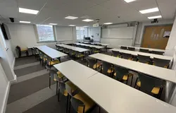 Fulton room showing white tables and a large white screen