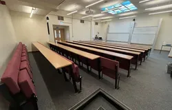 Fulton room J20 with cushioned seats attached to rows and two large white boards at the front of the room