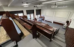 Old Medical School room 2.03 with old wooden benches and two large white screens