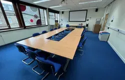 Tower T8 has a table set up in a boardroom style with a white screen at the front