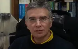 A headshot of Professor Vassilis Gorgoulis sitting in front of a row of books.