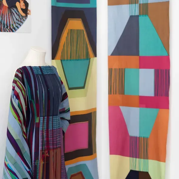 Textile designs of material and a dress with pleats as part of the Degree Show 2025 exhibition