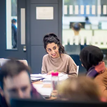students studying at a table in the library