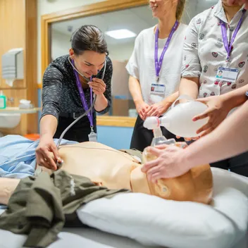 Undergraduate medicine students working with a dummy