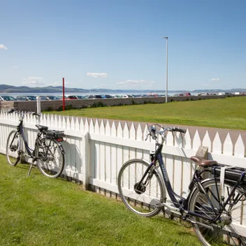 bikes alongside white fence looking out towards the river