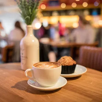 Cup of coffee and a cake on a table in a cafe