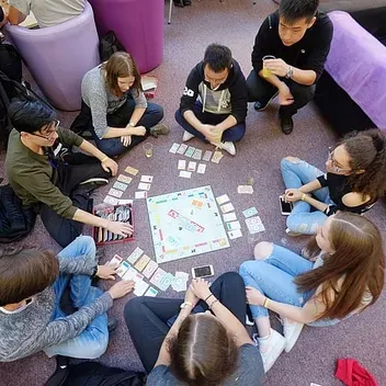 students sitting around a monopoly board