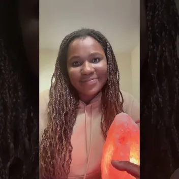 Tendayi sitting holding a crystal lamps