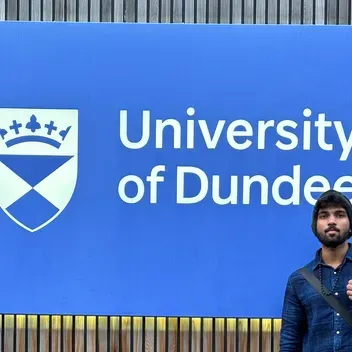 Aswin Poornachandran outside the Tower Building in front of the University of Dundee signage