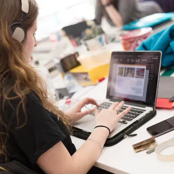 Student working on a laptop in DJCAD studio