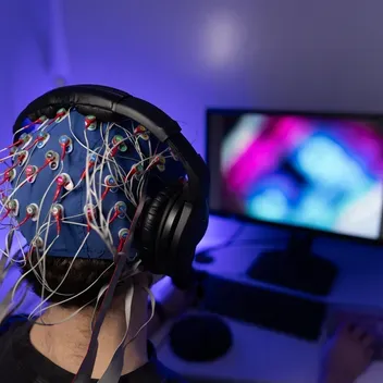 Psychology student sitting with Electroencephalogram EEG headset on