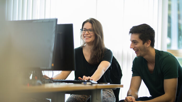 two students working on a computer