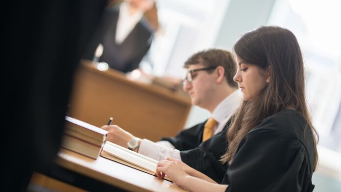 Law students looking at documents in the mooting room