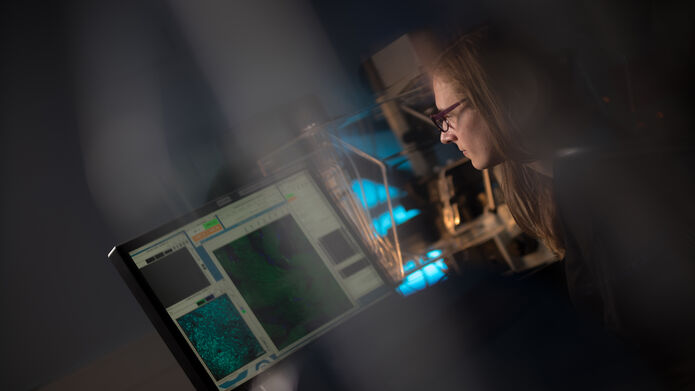 A student at a computer in the dark