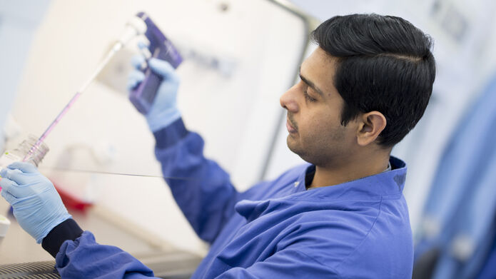 scientist filling up tube in lab