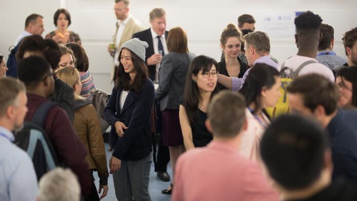 A group of alumni and students gather