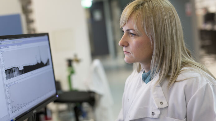 female scientist in lab coat working on a computer