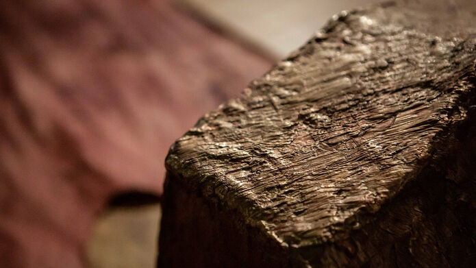 A clay model with line markings of a paint brush next to a red cloth