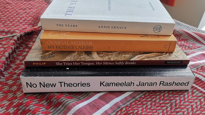 A stack of books on a red table clothe