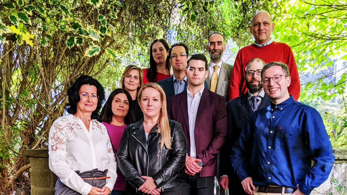 A group of people who took part of a visit to COI standing in a woodland area