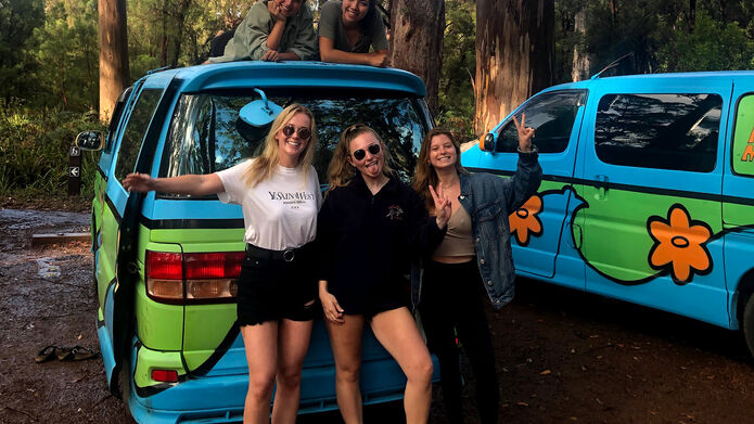 Students on study exchange posing outside van