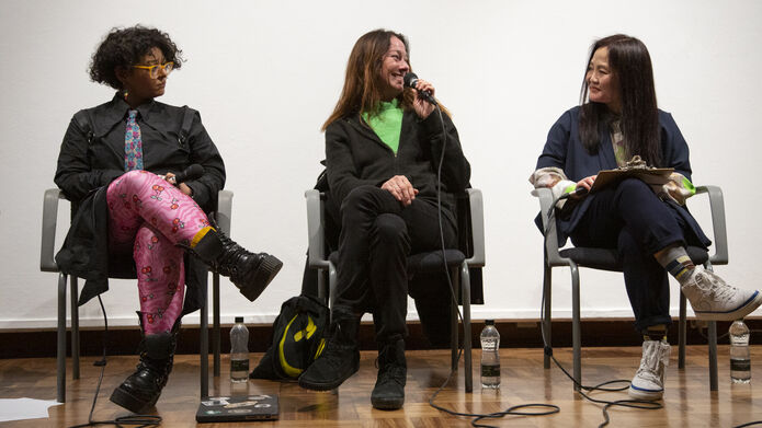 Three panellists speaking. Antje Ehmann is in the middle of layla-roxanne hill and Sophia Hao with the mic talking